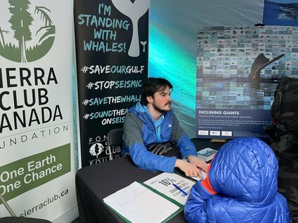 Simon L'Allier, Sierra Club Canada Marine Mammal Coordinator, at a table at IMPAC5 in Vancouver. IMPAC5 Policy Vancouver BC.